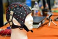 The electroencephalogram EEG head cap with flat metal discs electrodes attached to a white plastic modelÃ¢â¬â¢s head